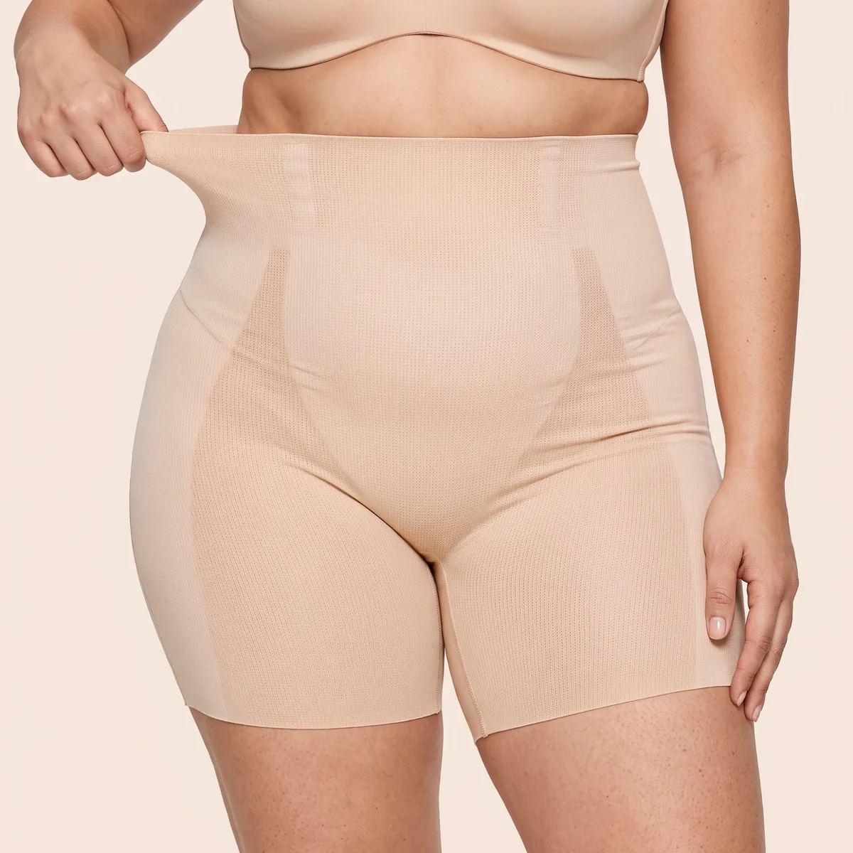 Linea Beige indossato, vista frontale: la mano tende il bordo della vita alta